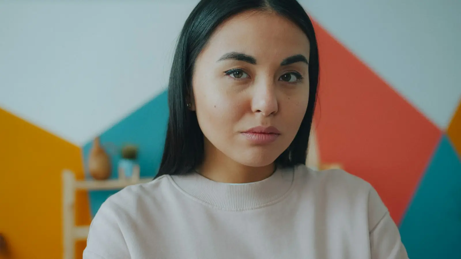 Vrouw met lang donker haar in een beige trui